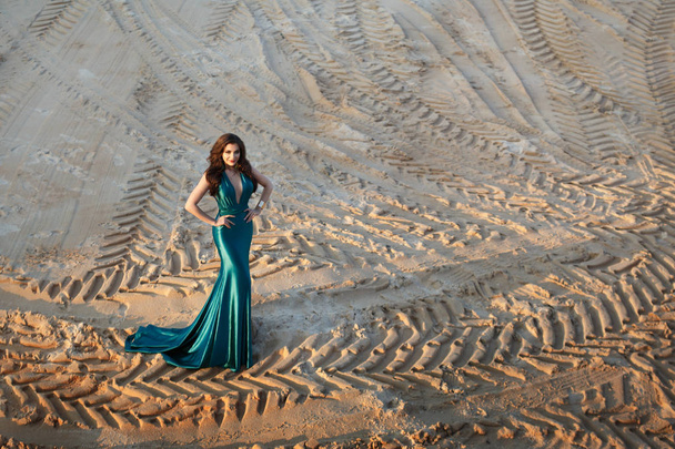 beautiful young woman in green dress posing in sandy desert - Foto, Imagem
