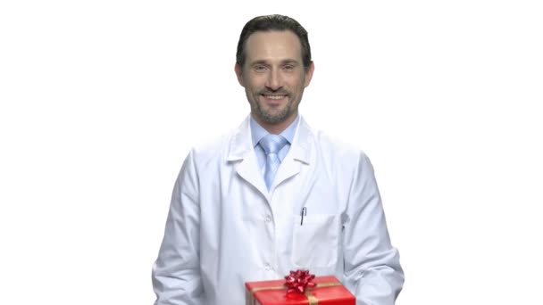 Mann im weißen Mantel bietet Geschenkbox an. - Filmmaterial, Video