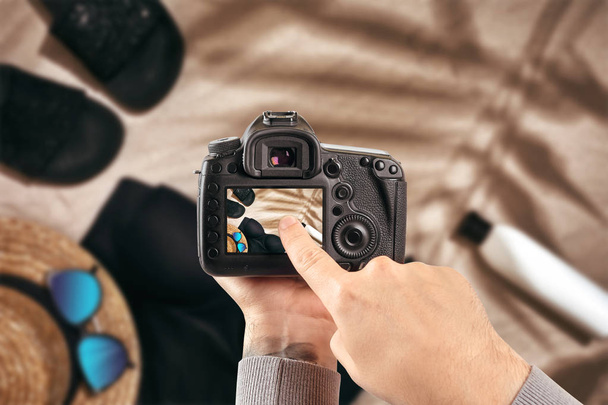 Цифровая однообъективная рефлекторная камера в руках. Фотограф делает фотографии. Мужские руки держат камеру крупным планом
 - Фото, изображение