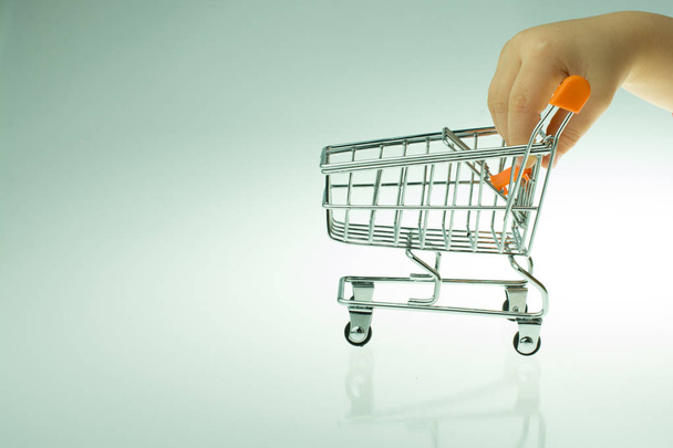 Shopping cart in the hand on white background - Фото, изображение