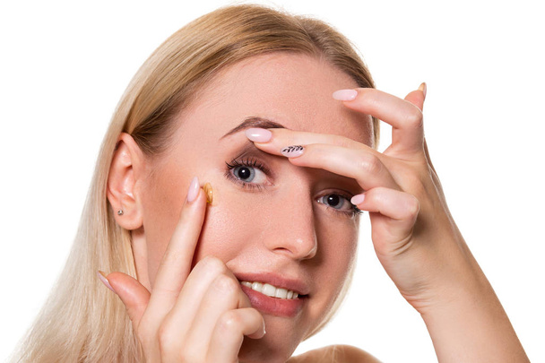 Молода жінка тримає контактну лінзу на індексному пальці з копіювальним простором. Крупним планом обличчя здорової красивої жінки збирається носити контактну лінзу
. - Фото, зображення