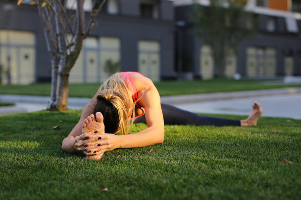 Fitness meisje stretching na training buiten - Foto, afbeelding