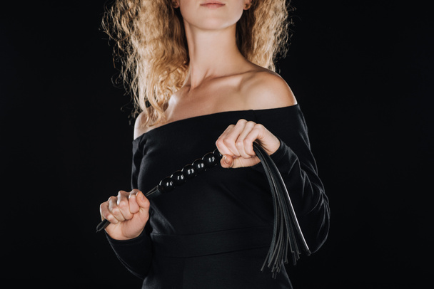 oříznutý pohled ženy s kůží Mrskání bičem izolované na černém - Fotografie, Obrázek