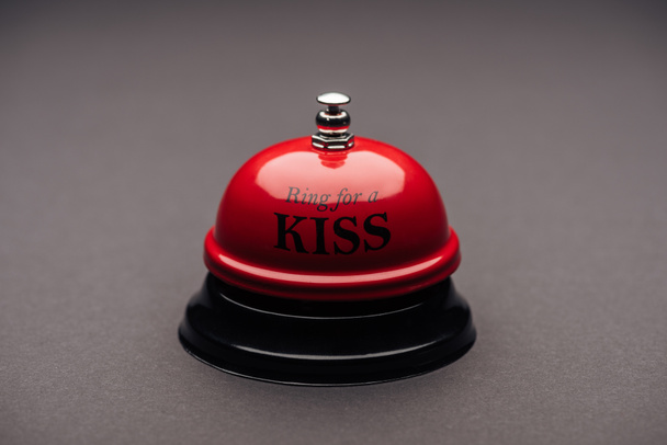 close-up de sino de serviço vermelho com "anel para um beijo" letras isoladas em cinza
 - Foto, Imagem