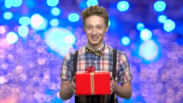 Roztomilý mladý muž dávat vánoční dárek pro vás. - Záběry, video