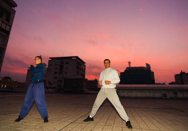 Young male friends doing parkour exercise at balcony on the rooftop - Φωτογραφία, εικόνα