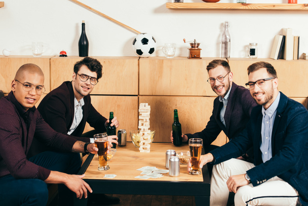 young multicultural businessmen with beer looking at camera spending time in cafe - Foto, imagen