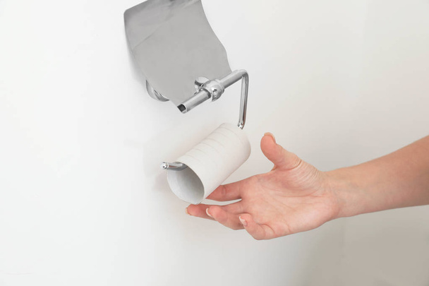 Woman reaching holder with empty toilet paper roll, closeup - Valokuva, kuva