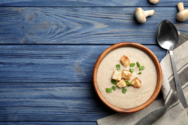 Flat lay composition with bowl of fresh homemade mushroom soup and space for text on wooden background - Fotografie, Obrázek