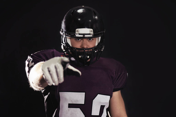 American football player wearing uniform on dark background - Zdjęcie, obraz