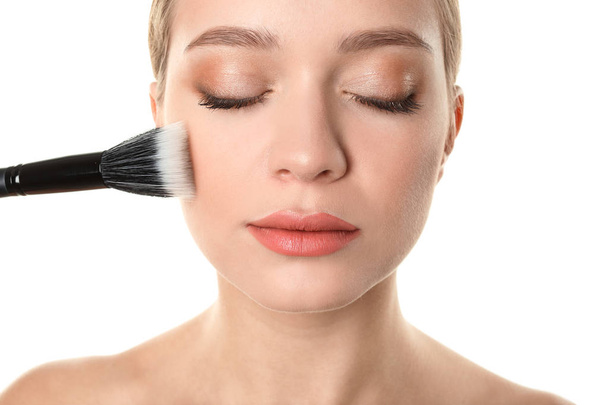 Retrato de una hermosa joven con cepillo de maquillaje sobre fondo blanco
 - Foto, Imagen