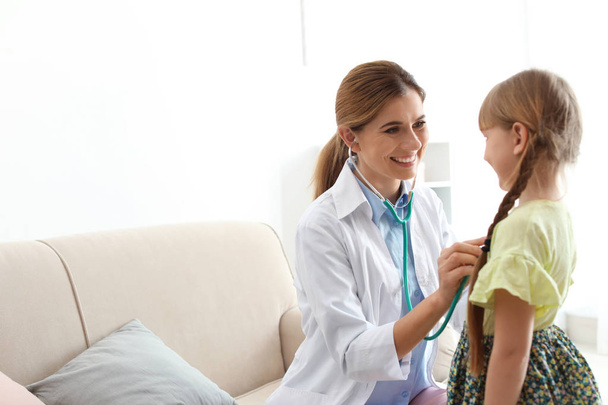 Children's doctor examining little girl at home. House call - Foto, imagen
