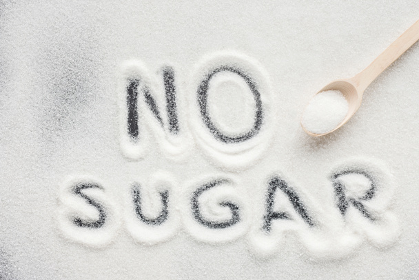 "senza zucchero "scritta su zucchero semolato con cucchiaio di legno
 - Foto, immagini
