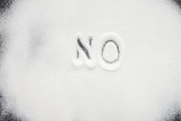 Ansicht des handgeschriebenen Wortes "Nein" auf einem Haufen Kristallzucker - Foto, Bild