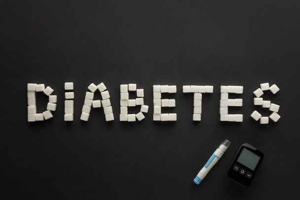 "lettering diabetico composto da cubetti di zucchero con glucometro su fondo nero
 - Foto, immagini