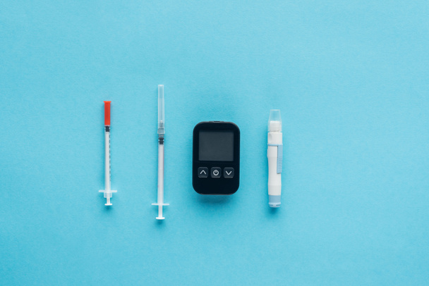 flat lay of medical equipment for diabetes control on blue background - Fotó, kép