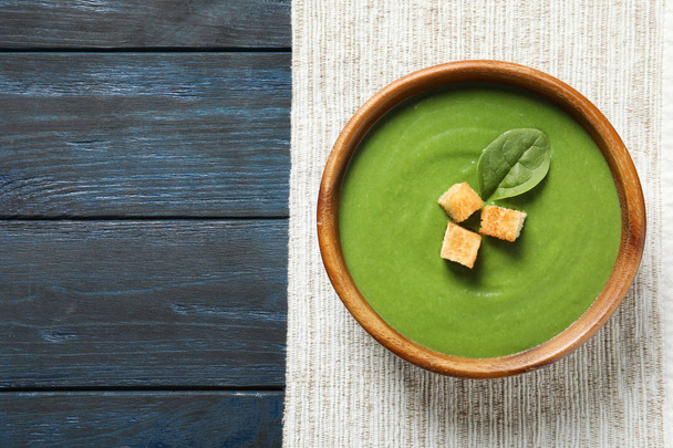 Fresh vegetable detox soup made of spinach with croutons in dish and space for text on wooden background, top view - Foto, Imagem