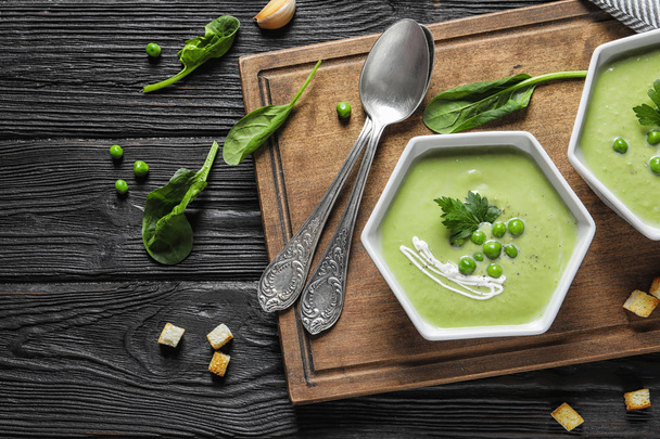 Fresh vegetable detox soup made of green peas served on table, top view. Space for text - Foto, Bild