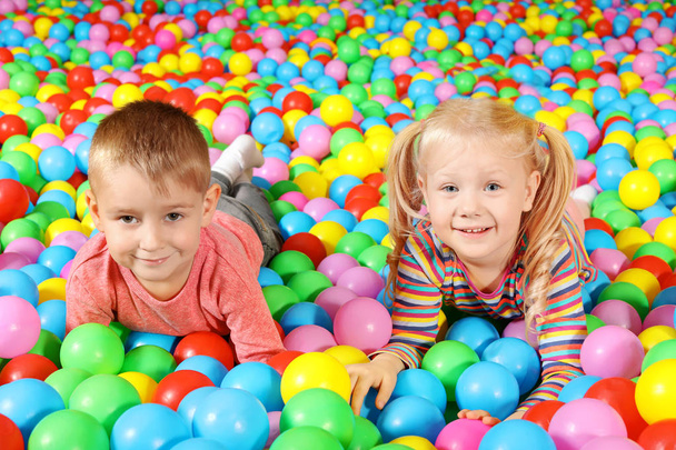 Cute children playing in ball pit indoors - Fotografie, Obrázek