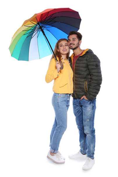Young romantic couple with bright umbrella on white background - Foto, imagen