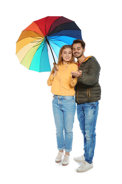 Young romantic couple with bright umbrella on white background - Fotoğraf, Görsel