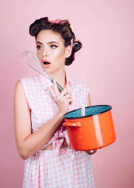 pretty girl in vintage style. pin up woman with trendy makeup. pinup girl with fashion hair. perfect housewife. retro woman cooking in kitchen. Cooking with passion - Foto, Imagen