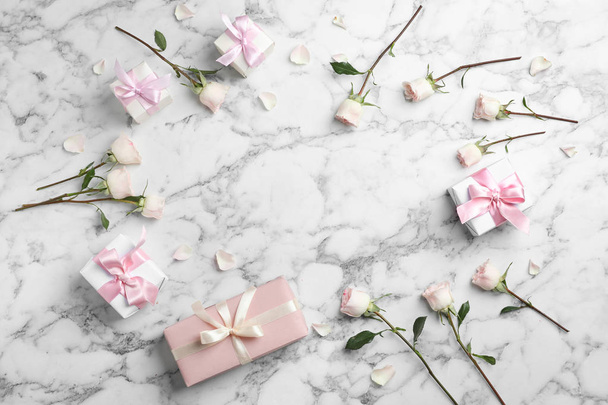 Flat lay composition with beautiful roses and gift boxes on marble background. Space for text - Fotoğraf, Görsel