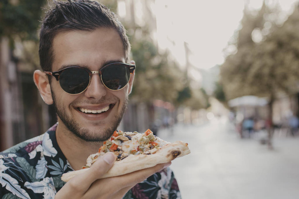Portret van de jonge eten in de straat fastfood, pizza - Foto, afbeelding