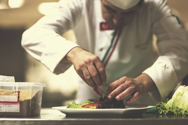 chef serving vegetable salad on plate in restaurant kitchen - Photo, Image