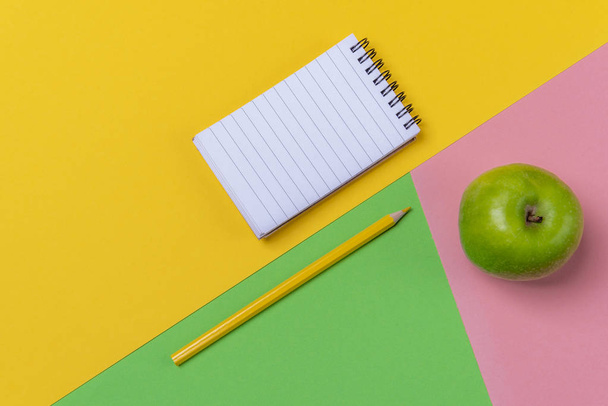 Caderno espiral em branco em uma mesa tricolor. De volta à escola. Acima
  - Foto, Imagem