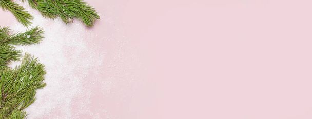 Рождественский фон, зеленые сосновые ветки на снежном розовом фоне. Творческая композиция с окантовкой и копированием пространства сверху плоской. Новый год, праздник, Рождество, украшения
 - Фото, изображение