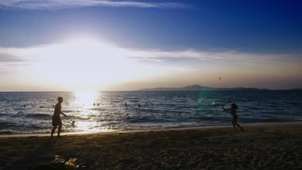 silhouettes. people play badminton on the beach at sunset. - Footage, Video
