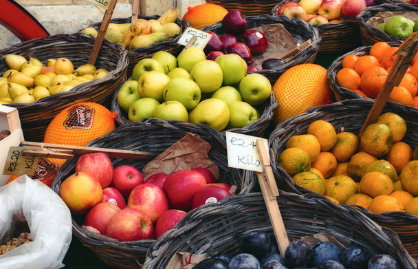 Marktverkäuferwagen mit abwechslungsreichem Obst in Weidenkörben - Foto, Bild