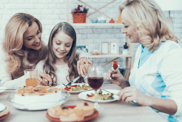 Happy Sitting Family Celebrating Birthday at Home. Cake on Table. Happy Family. Mother with Daughter. Smiling Women. Smiling Grandmother. Celebration Concept. Glass of Wine. Fruits on Plate. - Foto, Imagen