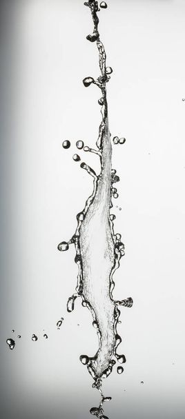 water splash with a lot of drops on a gray background - Fotó, kép