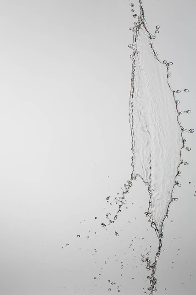 water splash with a lot of drops on a gray background - Zdjęcie, obraz
