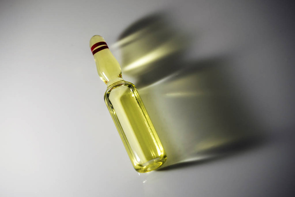 Vial detail with yellow medication, isolated side shadow on white background - Foto, afbeelding