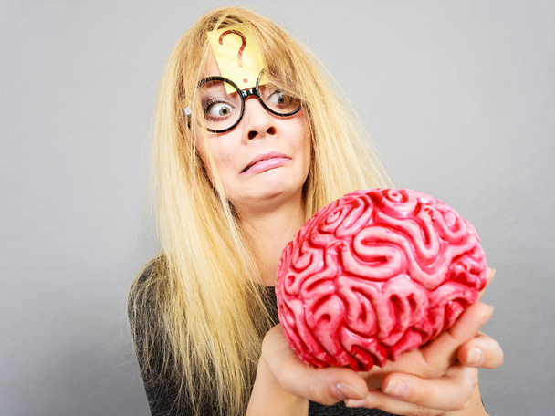 Mujer extraña sosteniendo el cerebro teniendo idea
 - Foto, imagen
