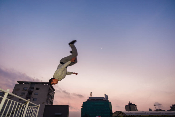 Фітнес-паркур чоловік стрибає високо на даху
 - Фото, зображення