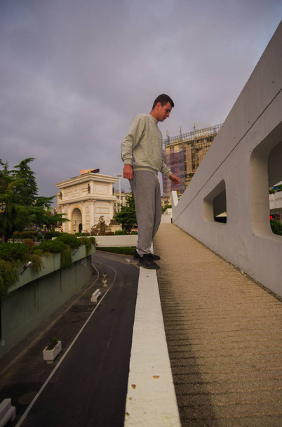 Courage Parkour-Mann trainiert Gleichgewicht am Rand der Mauer - Foto, Bild