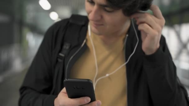 Man putting on headphones and listening to music - Filmagem, Vídeo