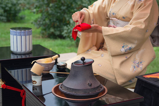 Женщина в кимоно проводит японскую чайную церемонию
 - Фото, изображение