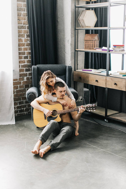 Beautiful couple spends time together, plays guitar, having fun - Photo, Image
