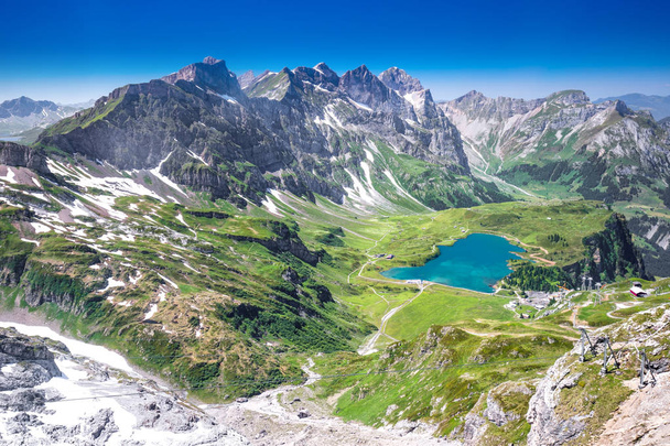 Zobacz Truebsee i Alpy Szwajcarskie z górskiej Titlis. Truebsee jest górskim jeziorem w Szwajcarii w kantonie Sankt Gallen, Szwajcaria, Europa.  - Zdjęcie, obraz