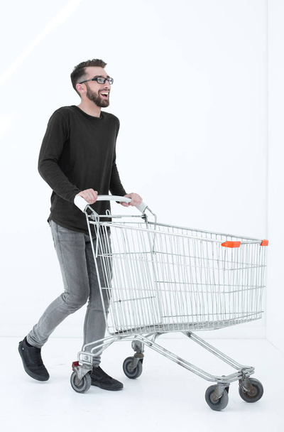 successful young man with a shopping cart - Фото, зображення