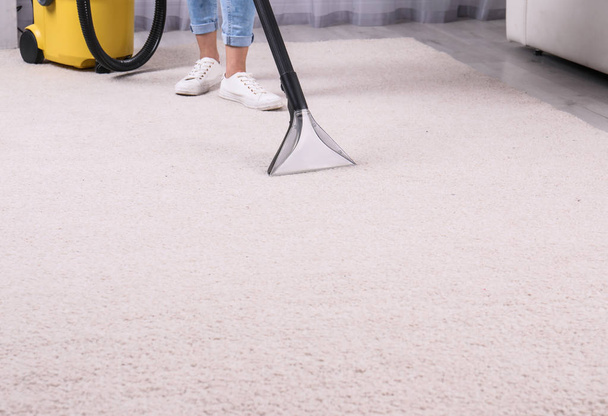 Woman cleaning carpet with vacuum cleaner, closeup. Space for text - Zdjęcie, obraz