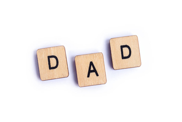 The word DAD spelt with wooden letter tiles. - Fotó, kép