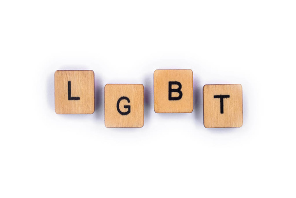 The abbreviation LGBT - standing for lesbian, gay, bisexual, and transgender, spelt with wooden letter tiles over a plain white background.  - Photo, Image