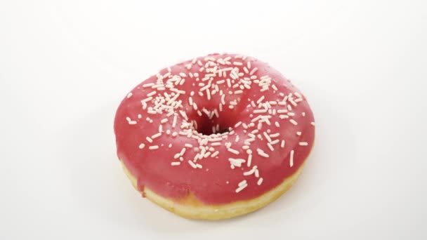 spinnen donut met roze suikerglazuur op een witte achtergrond - Video