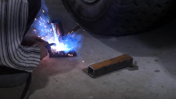 .A blacksmith or welder, with his welder, welding steel and iron, in extreme slow motion. The welder uses a mask to protect your eyes from sparks. concept: manual work, blacksmith, industry, welder - Footage, Video